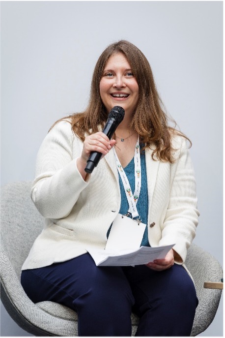 A picture of Virginia Atkinson holding a microphone at the Global Disability Summit in 2025